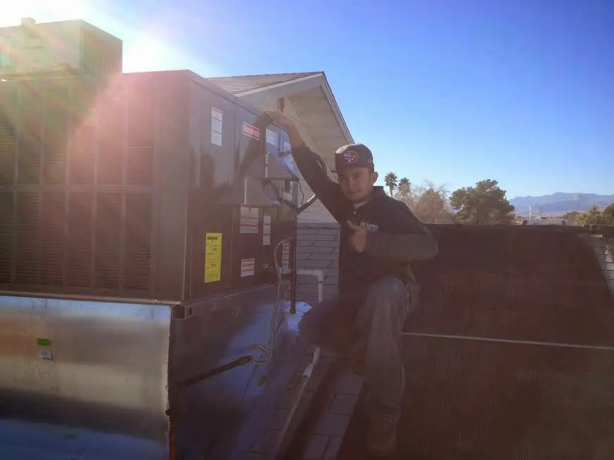 HVAC technician performing AC Tune-Up on a rooftop unit in Schroeppel